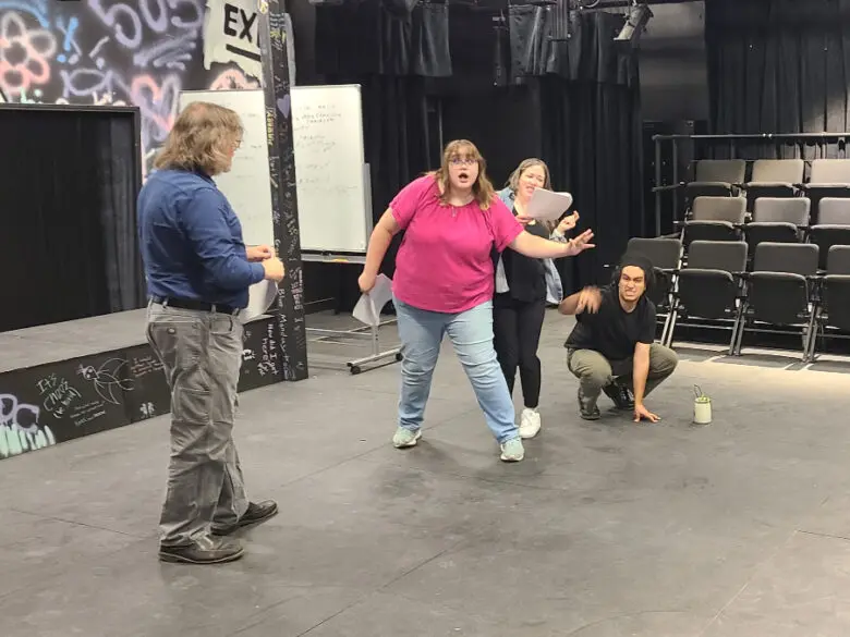 Actors rehears on stage.
