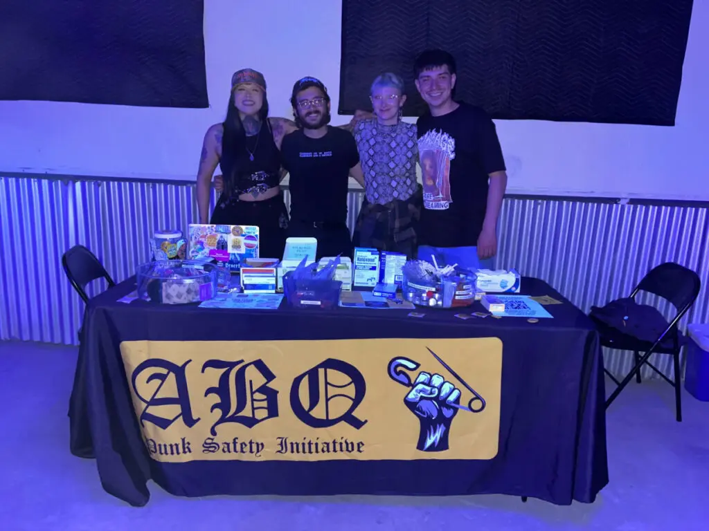 Members of the Punks Safety Initiative stand behind a table