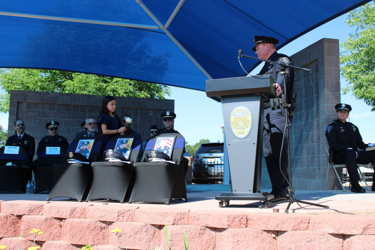 Rio Rancho Police Chief Stuart Steele watches as his granddaughter places a flower to honor the department's fallen officers at a memorial ceremony on May 14. (Julian Paras)