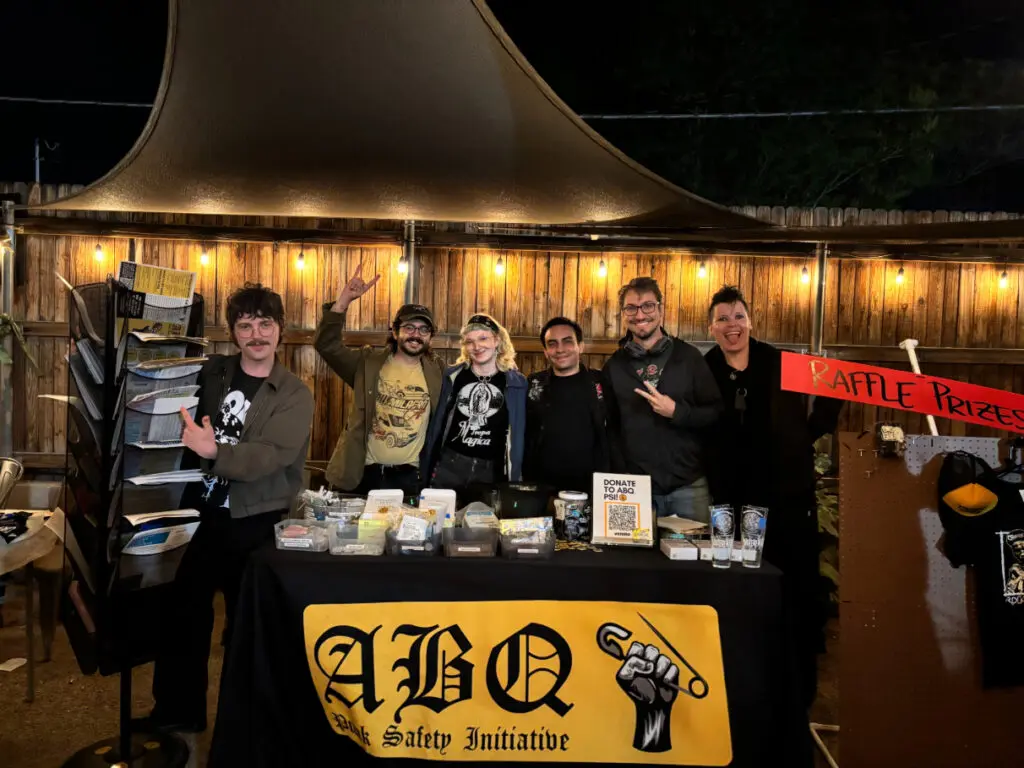 Punk Safety Initiative members stand behind a table.