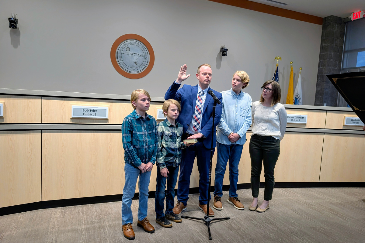 David Mann, center, is surrounded by his family as he is sworn in as the new District 4 councilor on July 23. (Kevin Hendricks)