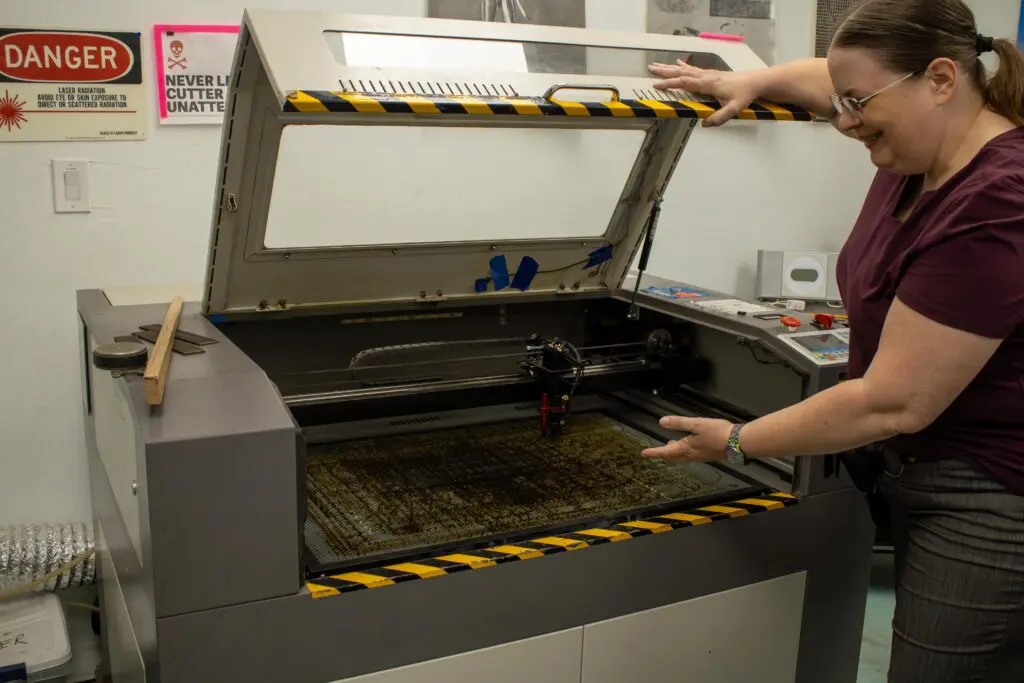 Rebecca Synder showing a laser cutter thats at Quelab (Photo by Sara Atencio-Gonzales)