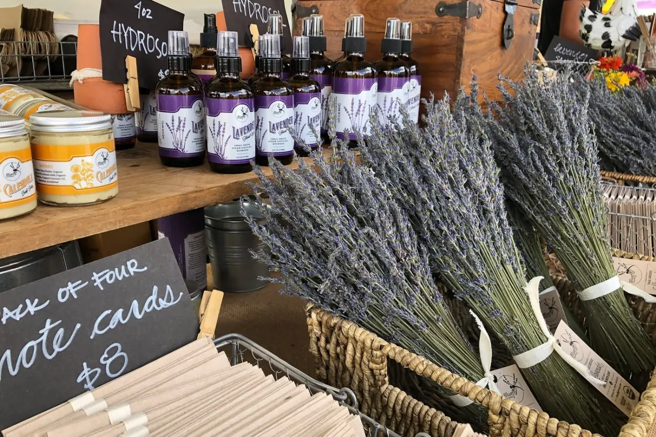 Lavender bundles and bottles of lavender oil sit at a market stand.