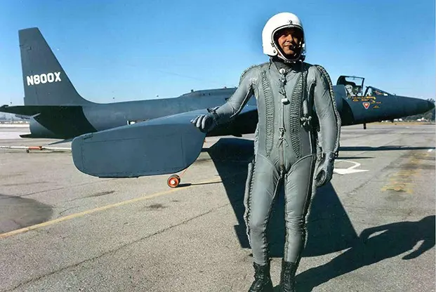 A 1960s pilot stand in front of a jet plane.