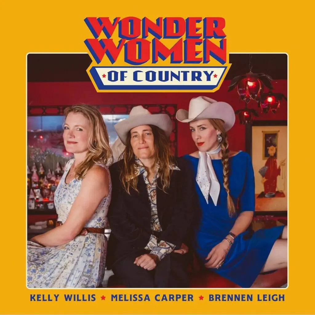 Three female country music singers, two wearing white cowboy hats, pose on an album cover.