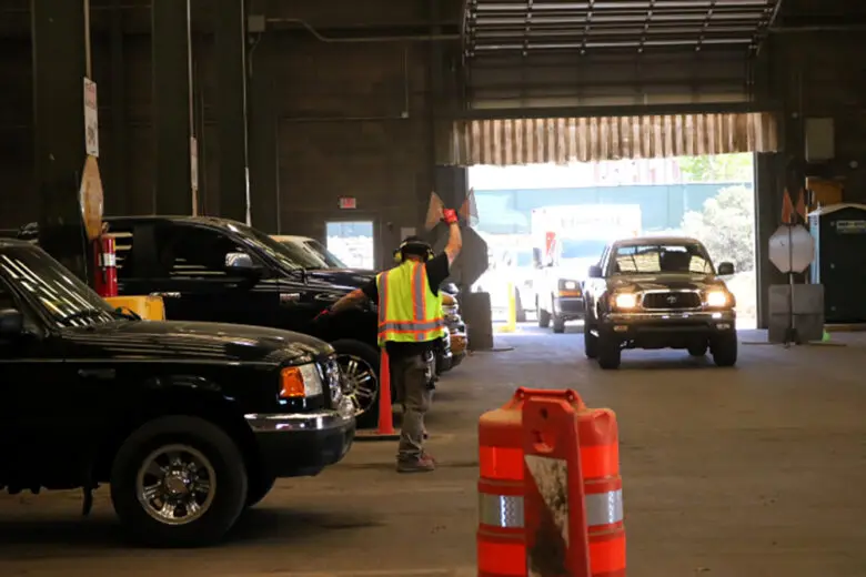 Drivers enter an Albuquerque convenience center as an employee directs traffic to an available drop-off bay. Under a new city ordinance, users must present proof of residency or pay an out-of-city rate. (CABQ)