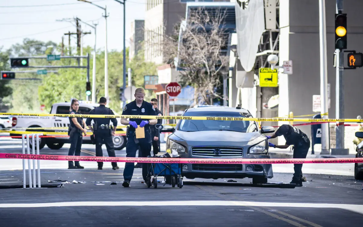 Albuquerque police officers gather evidence behind crime scene tape. Photo by Roberto E. Rosales/City Desk ABQ