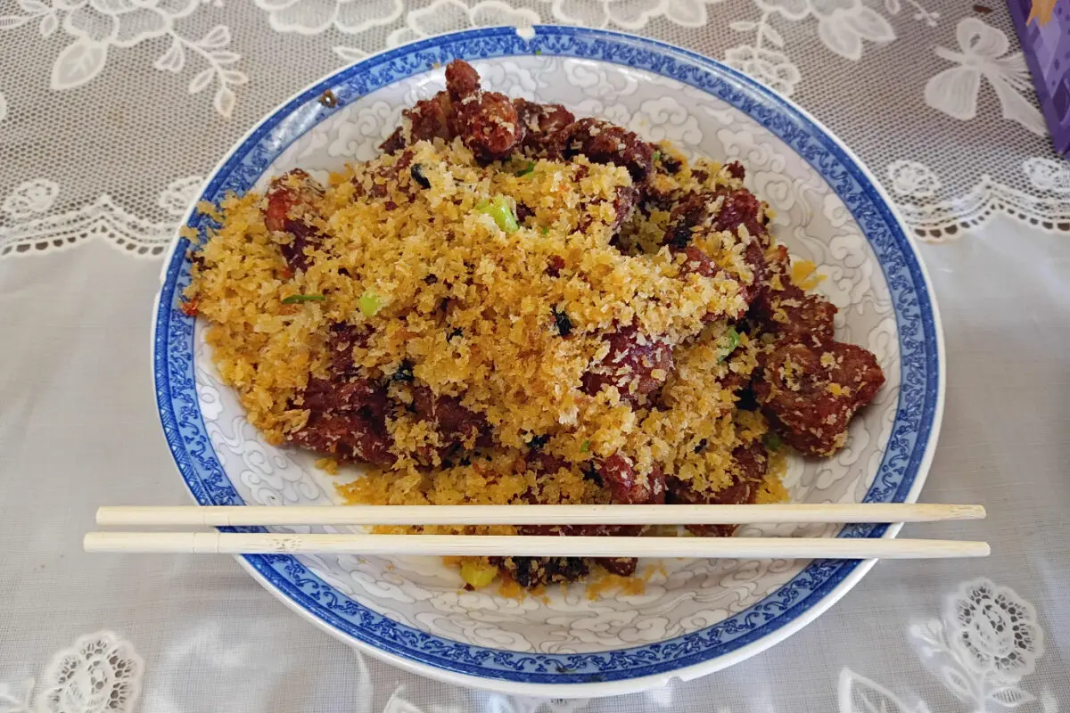 A dish of deep-fried pork ribs with chopsticks.