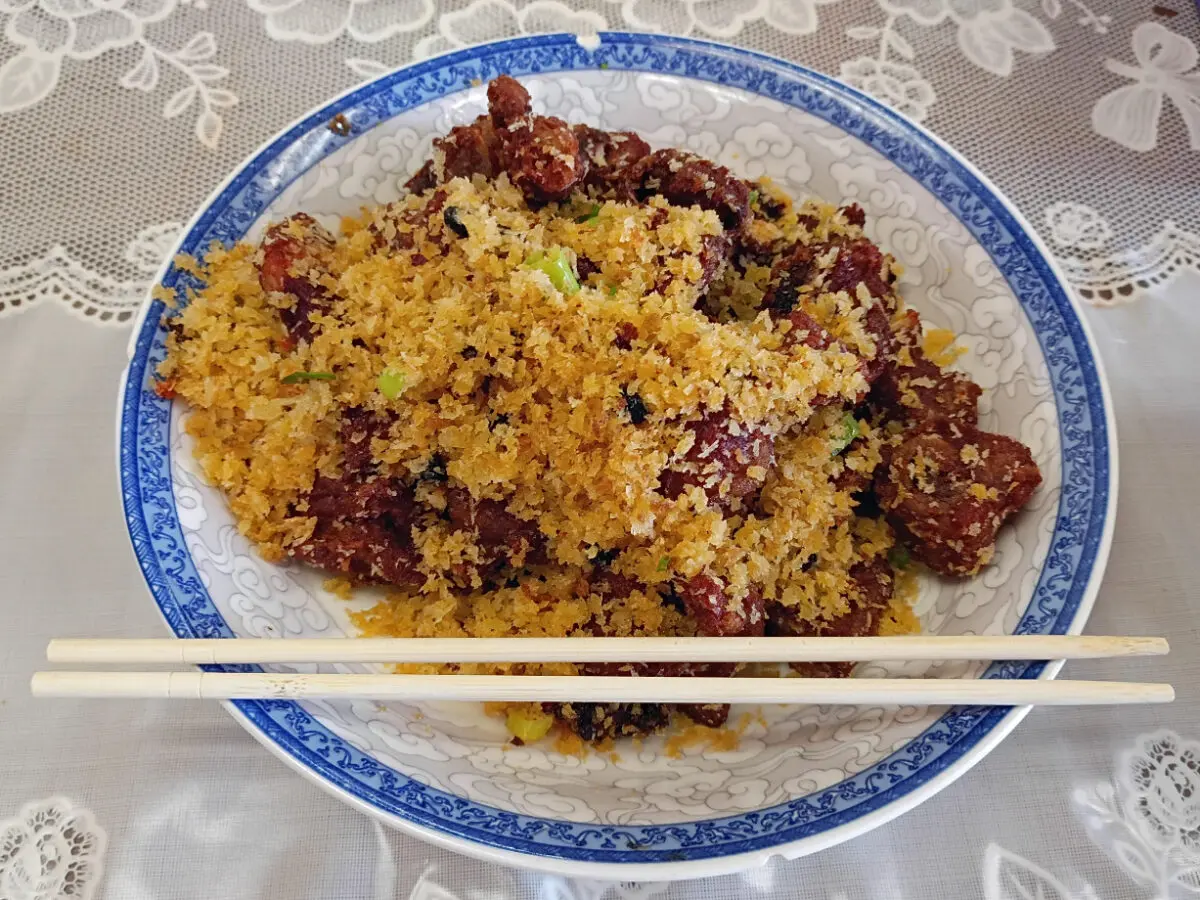 A dish of deep-fried pork ribs with chopsticks.
