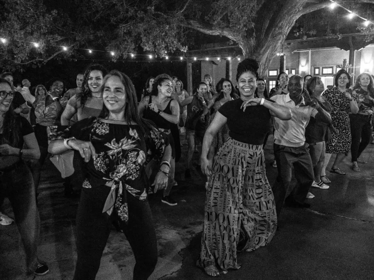 Men and women dance at an outdoor dance party.