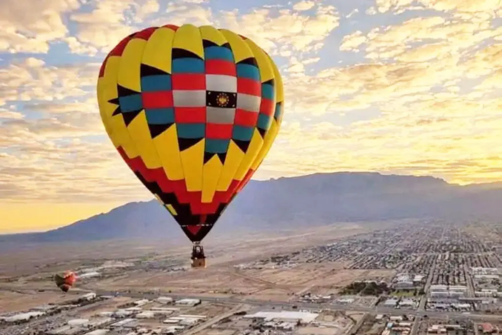 A hot air balloon floats over the mountains