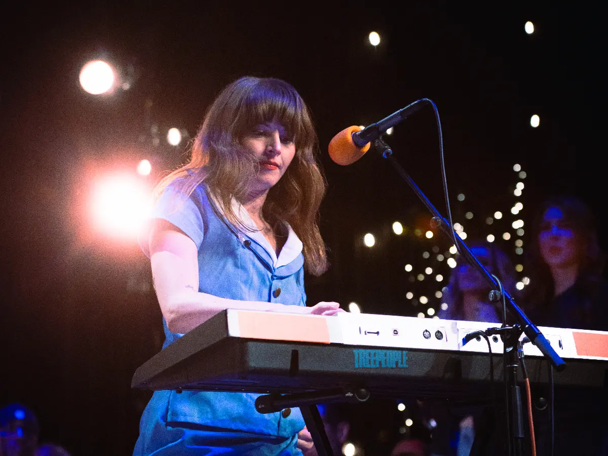 A woman plays keyboard on stage.