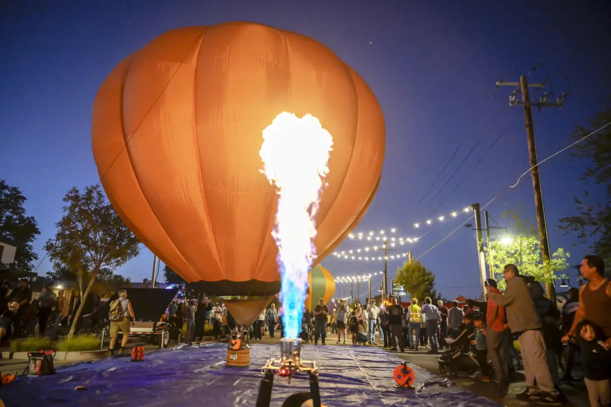 A small hot air balloon glows in the night.