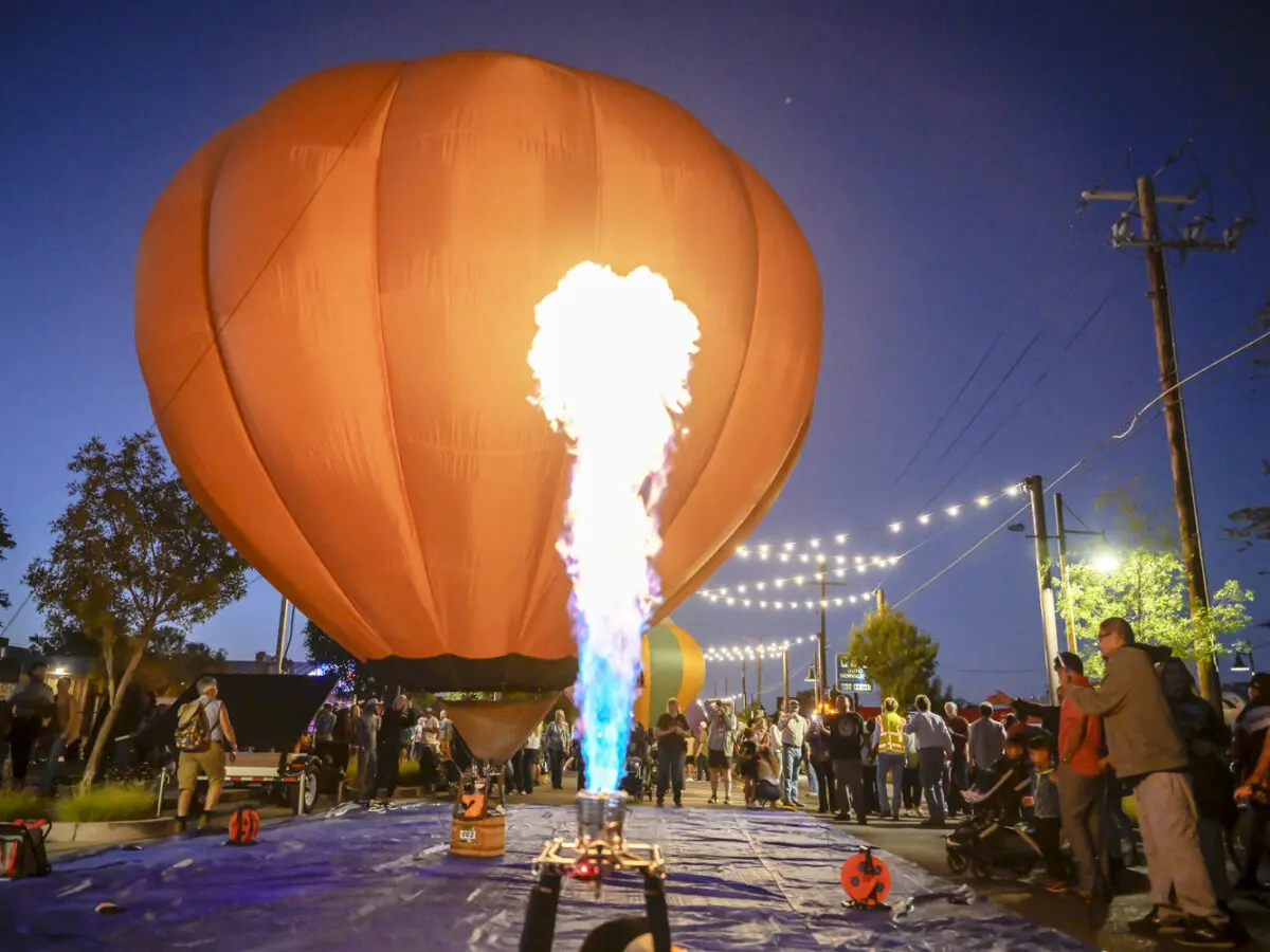 A small hot air balloon glows in the night.