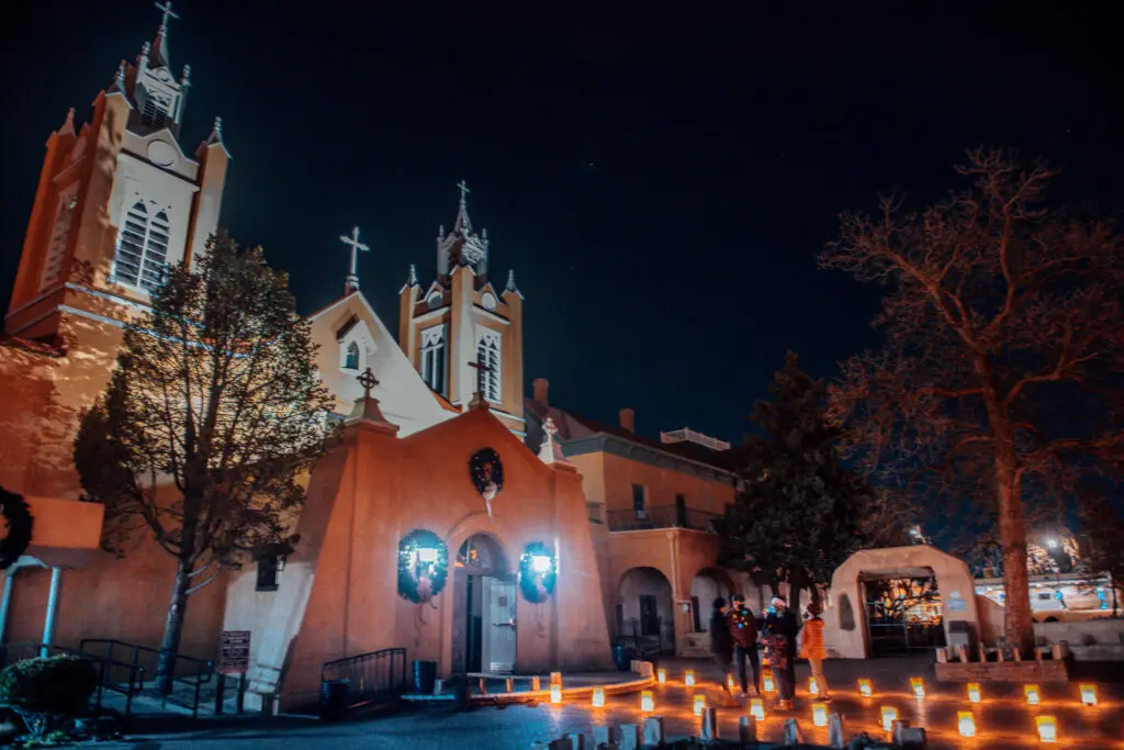 Luminarias glow outside San Felipe de Neri Church in Old Town Plaza in Albuquerque. Photo by Roberto E. Rosales for the Paper Credit: The Paper.