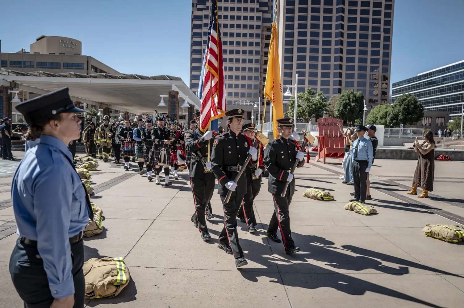 Firefighters parade the American flag on Civic Plaza.