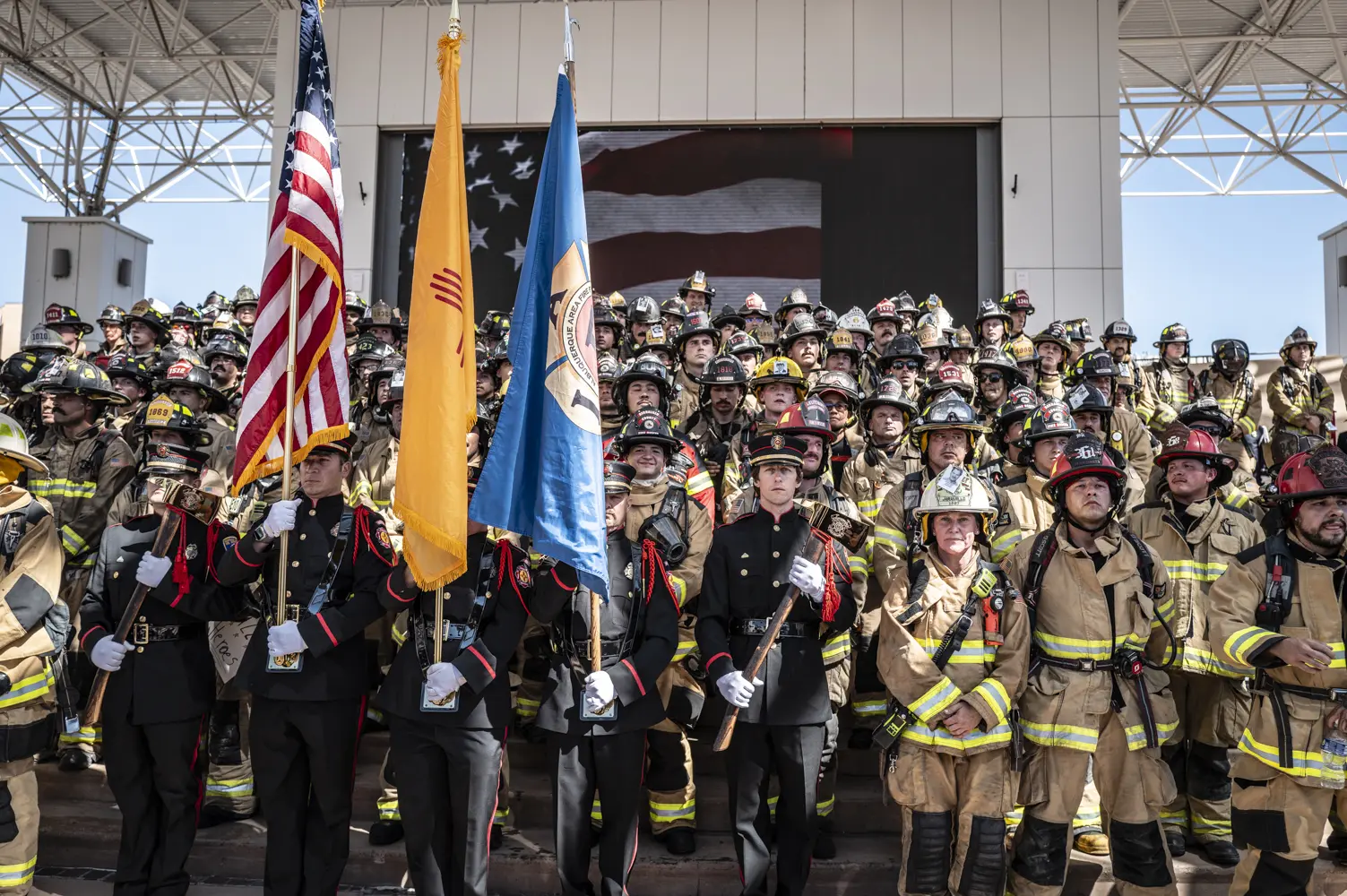 Police and fire fighters stand during a ceremony.