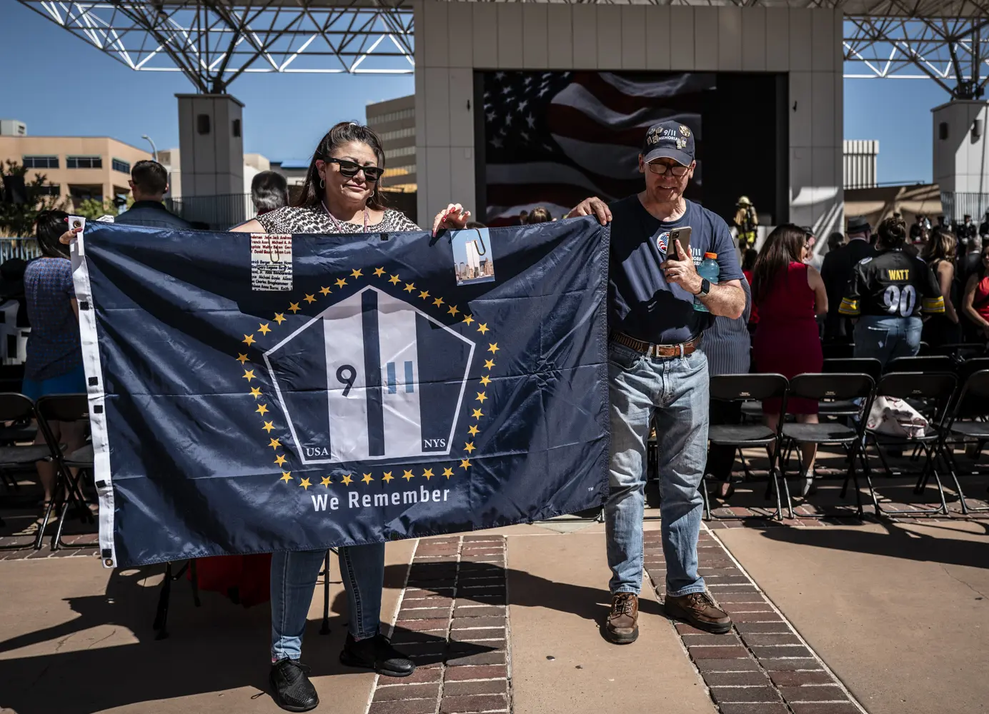 Two people hold a 9/11 Memorial flag.