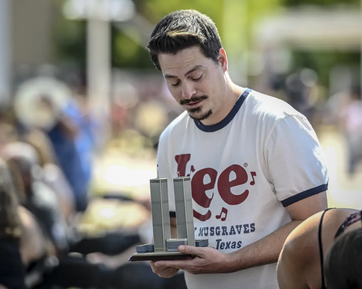 A man holds a model of the Twin Towers.