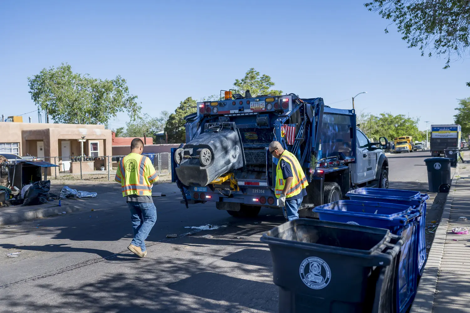 City workers clean up an encampment near Utah and Chico streets in Albuquerque’s International District in May 2024. The encampment had grown to occupy an entire lot in the residential area before the city cleared the site. Photo by Roberto E. Rosales/ City Desk Abq.