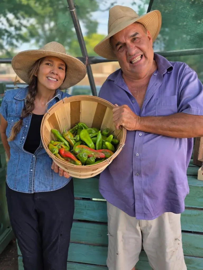 Jimmy Wagner (left) holding a basket of green chiles at Big Jim Farms (Courtesy of Big Jim Farms) 