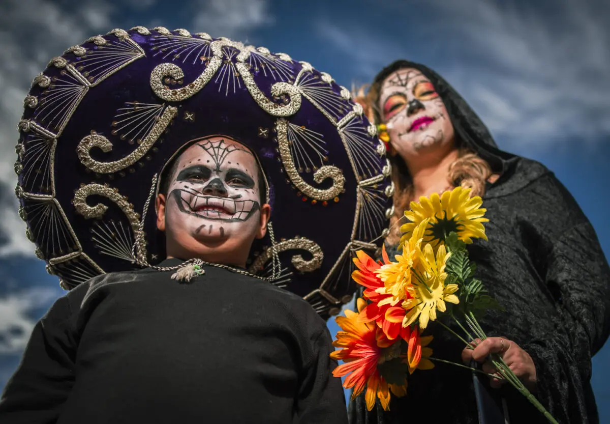 A child and woman dressed up at the Muertos y Marigolds parade. (Photo by Roberto Rosales)