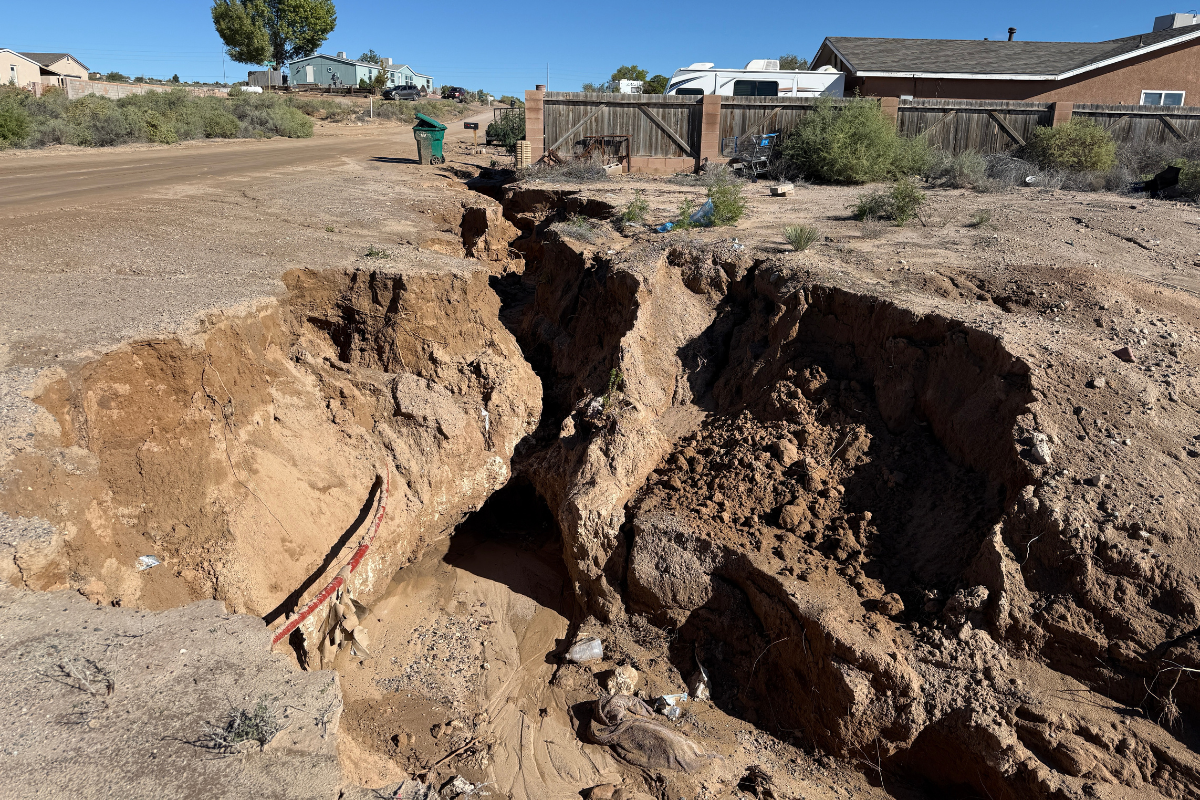 Along 10th Street SE just south of Unser Boulevard, runoff gouged channels several feet deep beside the roadway, chewing away the shoulder. (Roberto E. Rosales)