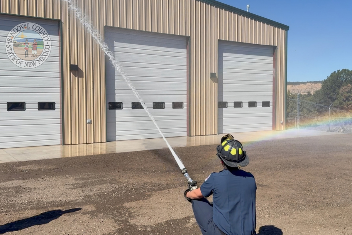 Dakota Trujillo, firefighter at Fire Station 34, performs the wet down ceremony. Rainbow (far bottom right) was a nod from Nature. (SandCo)