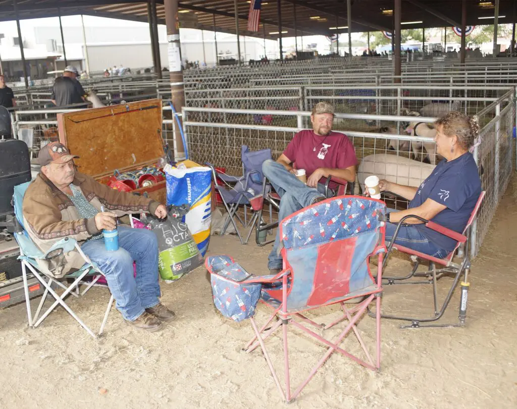 Pictured from left to right are A.D. Richins, Sr., A.D. Richins and Sue Richins relaxing under the livestock shed at the New Mexico State Fairgrounds Wednesday.