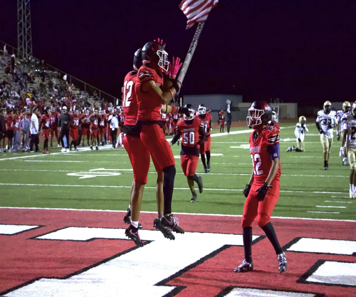 Daniel Guevara (7), Francisco Guzman (12) and Alex Lomeli (22) celebrate in the end zone after a touchdown.