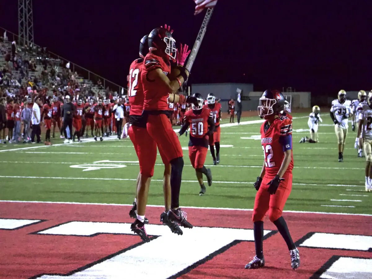 Daniel Guevara (7), Francisco Guzman (12) and Alex Lomeli (22) celebrate in the end zone after a touchdown.