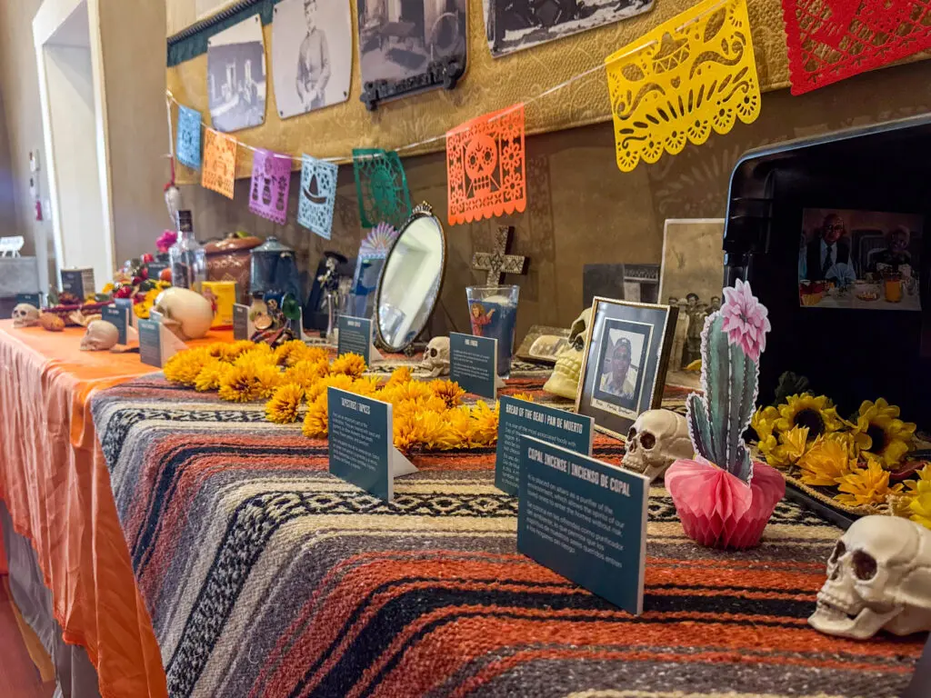 An ofrenda at the Ofrendas Comunitarias and Cultural Traditions exhibit that explains each part of an ofrenda for guests (Photo by Sara Atencio-Gonzales) 