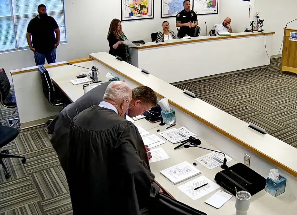 Doug West signs paperwork after the Edgewood Town Commission appointed him to fill the vacant District 5 seat as Judge William White stands beside him on Oct. 13, 2026. (Screenshot courtesy of the Town of Edgewood)