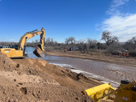 Heavy equipment removing dirt to lower the entrance of the constructed side channel along the Rio Grande on March 3, 2026, maintaining downstream flows during Phase 1 of the Corrales River Mile 199 Project, looking east. Reclamation photo