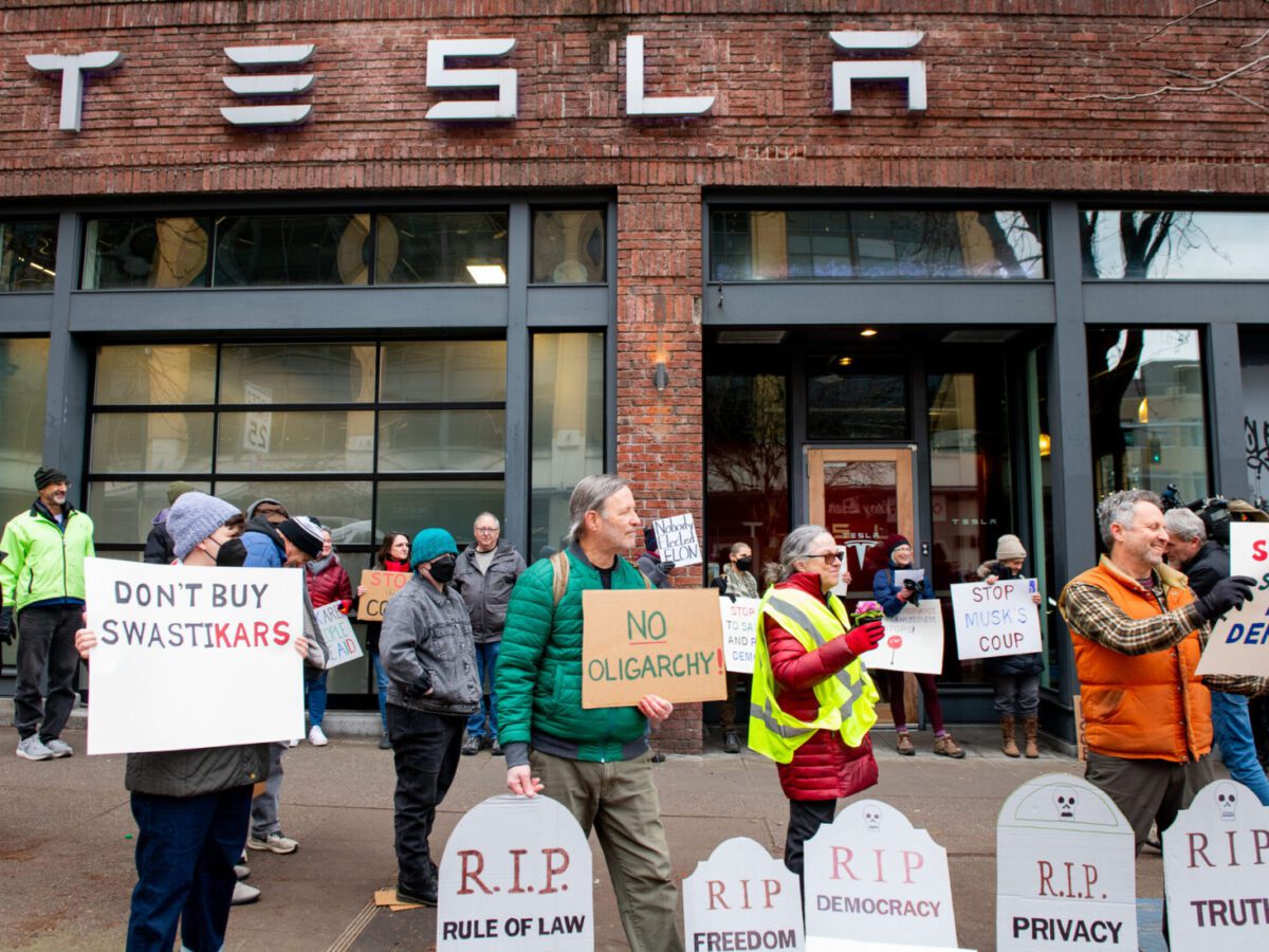 Demonstrators gather in opposition to Tesla and U.S. DOGE Service-related cuts by billionaire CEO Elon Musk in front of a dealership in Seattle on Feb. 13. Daniel Berman/For The Washington Post