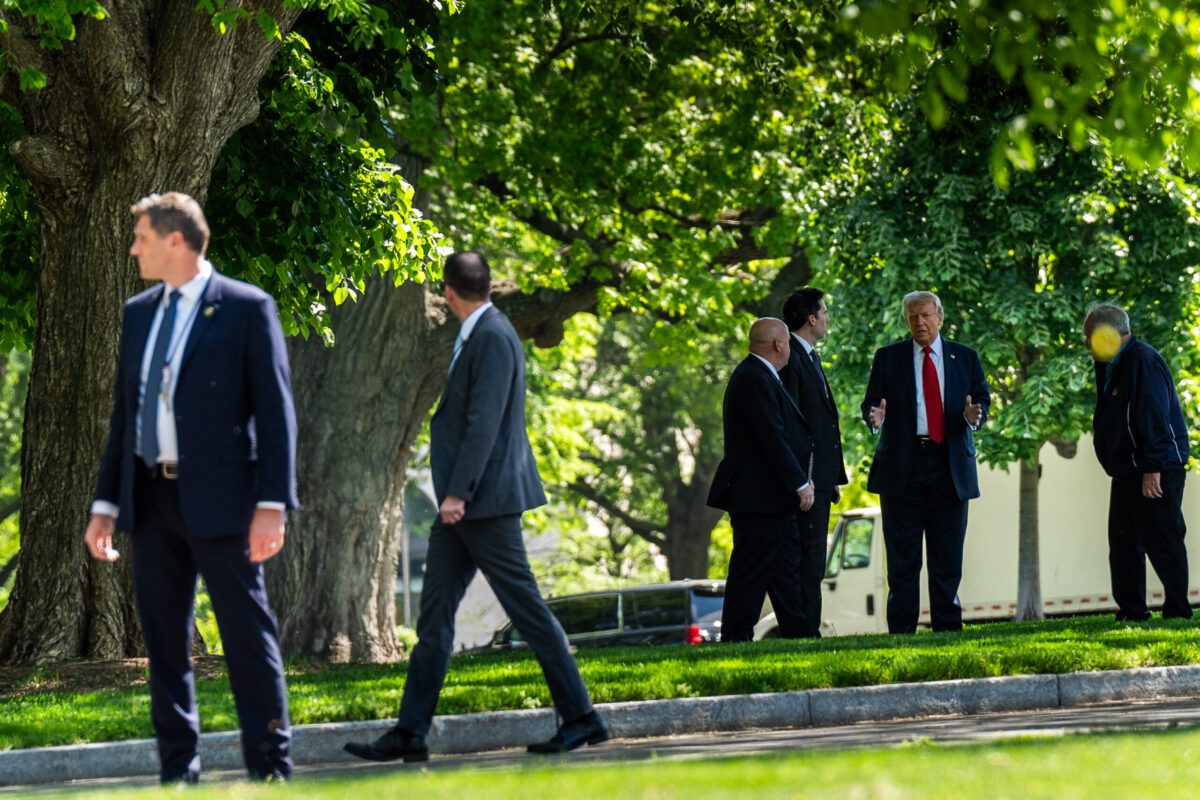 President Donald Trump and staff members evaluate locations for new flag poles on the North Lawn of the White House on Wednesday. Demetrius Freeman/The Washington Post