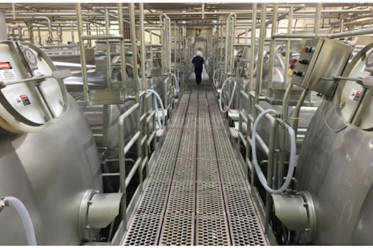 A worker walks between cheese processing tanks at a Southwest Cheese plant / Presentation to NM Legislature, 2016