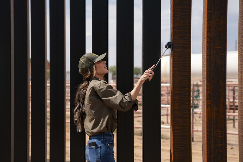 Department of Homeland Security (DHS) Secretary Kristi Noem paints the steel border wall black in Santa Teresa, New Mexico, August 19, 2025. (DHS photo by Tia Dufour)