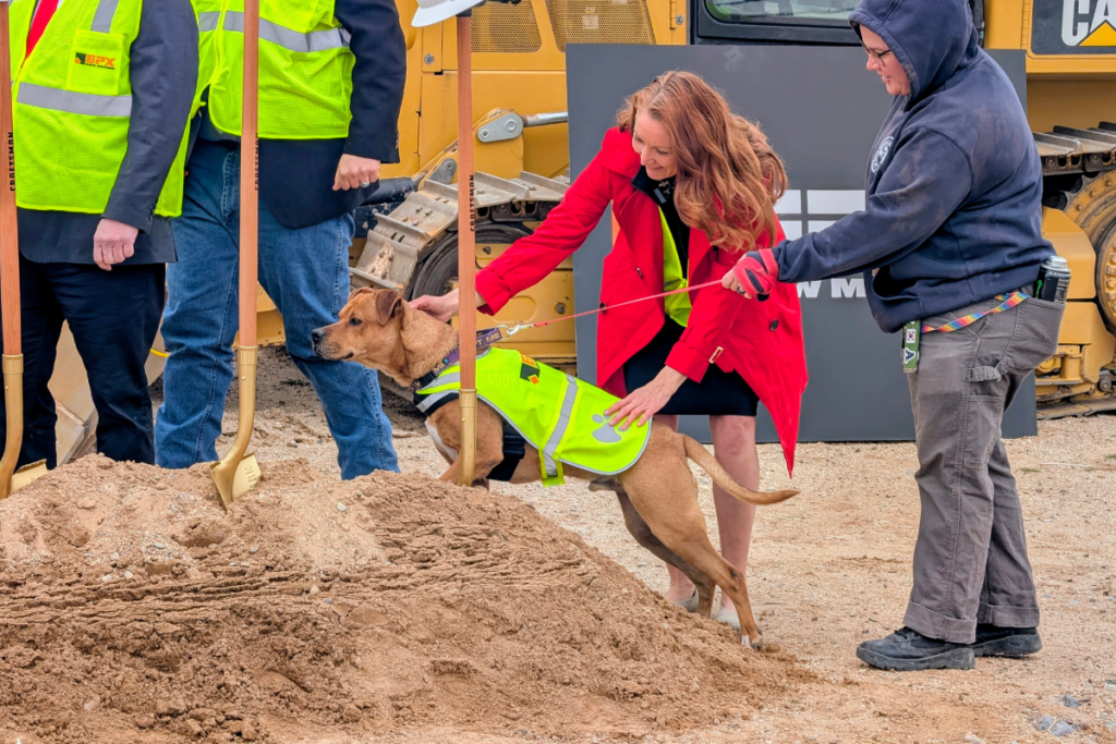 U.S. Rep. Melanie Stansbury plays with a dog before the groundbreaking ceremony for Sandoval County's new Animal Resource Center. (Kevin Hendricks)