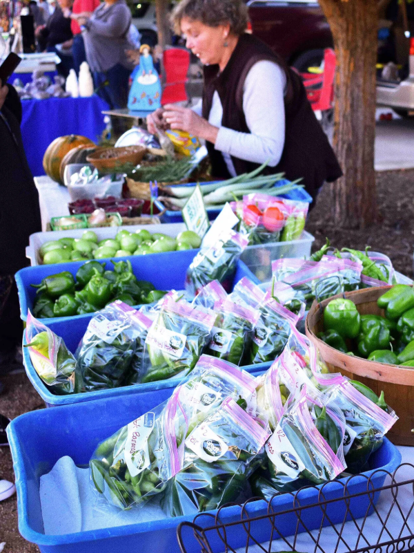 A woman sells produce at a farmers market