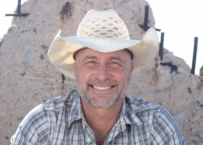 Head shot of a man wearing a cowboy hat.