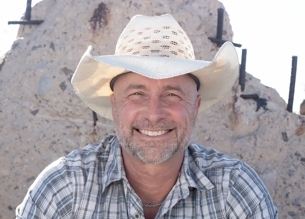Head shot of a man wearing a cowboy hat.